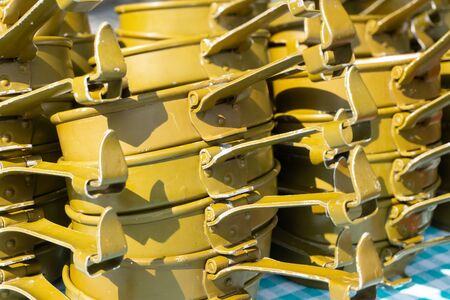 A lot of army metal utensils piled  in stacks on the tableの写真素材