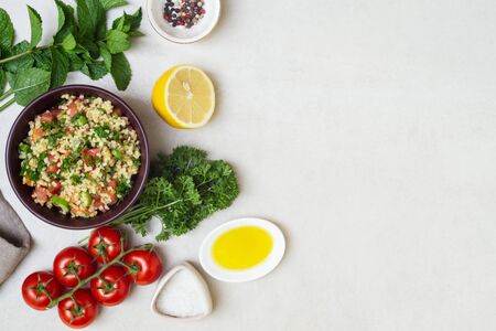 Lebanese traditional salad taboule soaked bulgur and ingredients-parsley, mint, lemon, tomatoes, olive oil, salt and pepperの写真素材