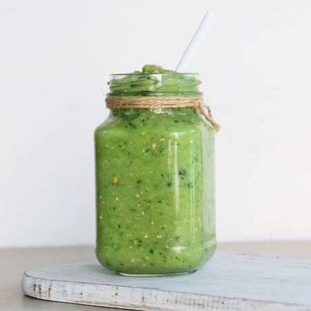 Vegetable green smoothie in a glass jar on a light backgroundの写真素材