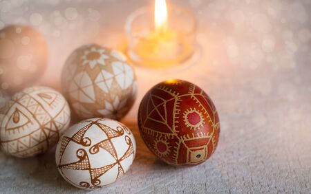 Easter eggs with traditional geometric decor and a burning candle. Copyspaceの写真素材