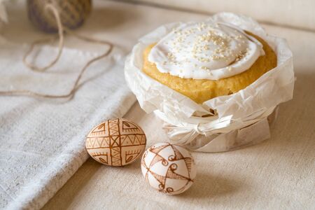 Traditional easter cake and decorated easter eggs on a linen tablecloth