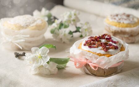 Easter holiday. Traditional Easter cakes and blossoming apple tree branches on a linen tableclothの写真素材