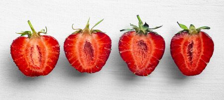 Halved ripe strawberries on a white background. Close-up