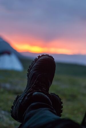 Feet in trekking boots against the sunset sky. Close-upの写真素材