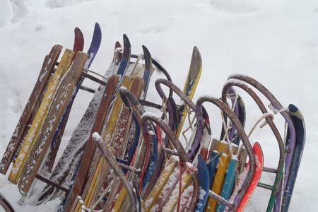 Many old children sledges are standing in the snowの写真素材