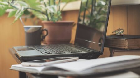 Laptop, smartphone and cup of coffee at home workplace. Home office of freelancerの写真素材