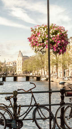 Bicycle parked near a city canal in Amsterdam, Netherlandsの写真素材