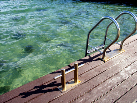 ladder descending to the water near the seaの写真素材