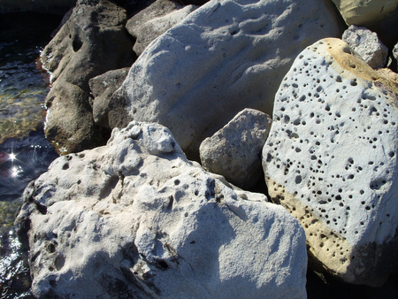big stones with holes by the seaの写真素材