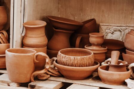 a set of ceramic products made of unburned clay standing on a shelfの写真素材