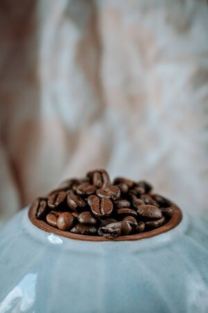 coffee beans close- up on a round blue plate. side viewの写真素材