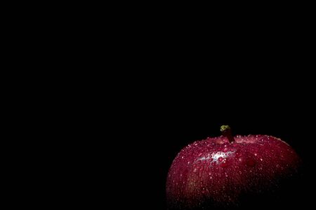 one red Apple with dew drops on a dark backgroundの写真素材