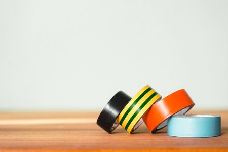 insulation tape of different colors for electrical work. insulation tape of four colors is on the tableの写真素材