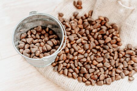 raw pine nuts spilled across the table. concept of harvesting in a small bucketの写真素材