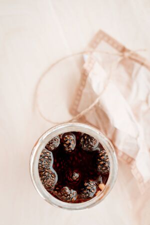 pine cone jam in a glass jar on a pastel background. vegetarian sweet dessert close-up, copy the...