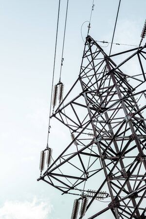 high-voltage tower with wires against the blue sky. vertical photo