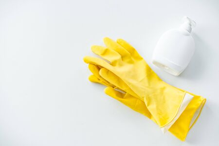 a pair of rubber gloves for cleaning the premises and a soap containerの写真素材