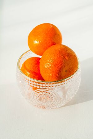 Oranges, close-up, in a crystal vase on a white backgroundの写真素材