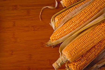 ripe corn cobs on a wooden table