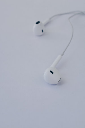 in-ear headphones are wired. White wired headphones lie on a white background. The concept of modern...
