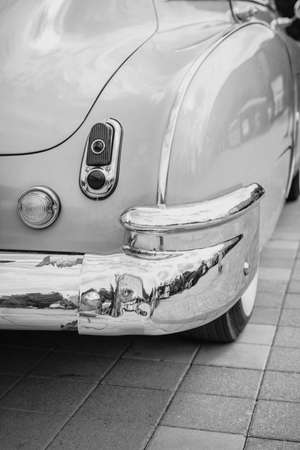 Retro-styled back of a classic car with headlights in black and white image. The headlights are finished in shiny chrome. The concept of a poster on the wall.の写真素材