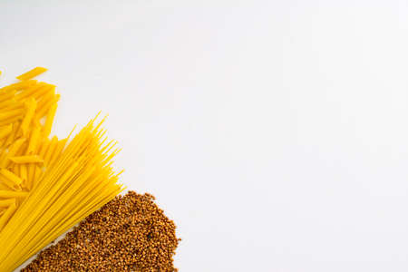 A variety of types and forms of dry Italian pasta. Food from the pasta collection on a white background. Assortment of raw pasta and buckwheat. the concept of ingredients for cookingの写真素材