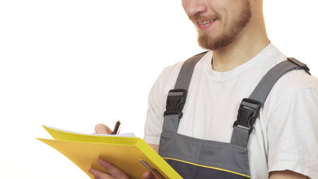 Cropped shot of a industry worker smiling making notes on clipboardの写真素材