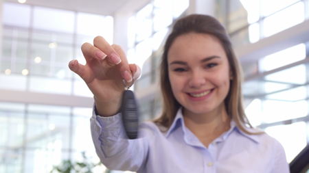 Girl shows car key at the dealeshipの写真素材