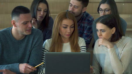 Students look at laptop screen