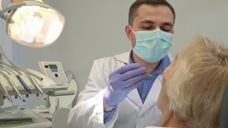 Dentist begins check up of female patientの写真素材