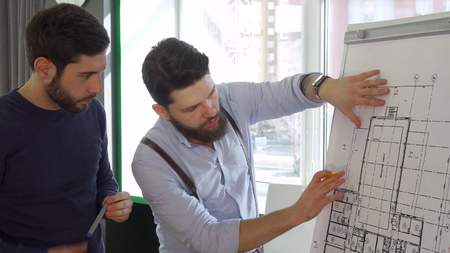 Architect moves his hand over the design of the building