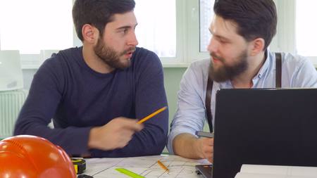 Architect points his pencil on laptop screenの写真素材