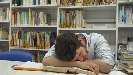 Guy sleeps at the libraryの写真素材