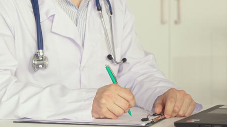 Male doctor working at the tableの写真素材