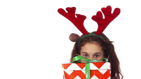 A sweet girl hides behind a Christmas gift boxの写真素材