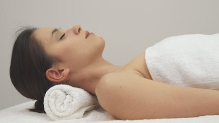 Girl lies on her back on the massage tableの写真素材