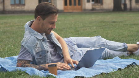 Guy lies on the lawn on campusの写真素材