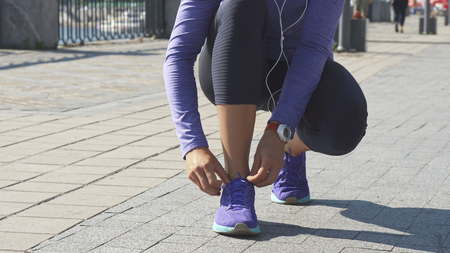 Woman stops to fix string on sneakers