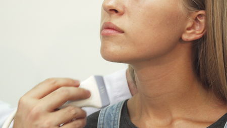 The doctor makes an ultrasonic investigation of lymph nodesの写真素材