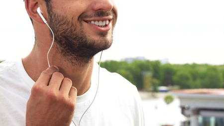 A young guy makes a sound in his headphones louder