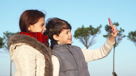 Modern children make selfies on the phoneの写真素材