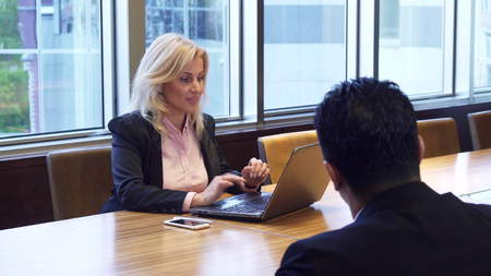 Beautiful business woman is talking while sitting at the computer