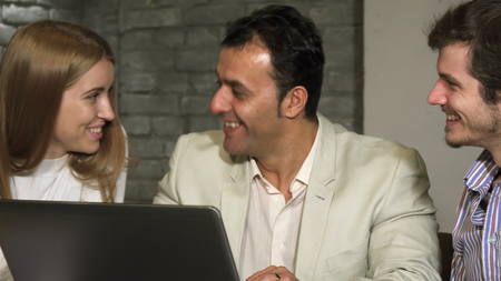 Group of business people laughing and talking at the office