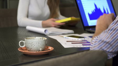 Cup of coffee on the table at the office business people having a meetingの写真素材