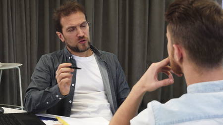 Mature businessman talking to his colleague at the boardroom