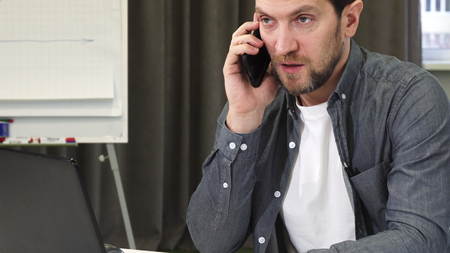 Close up of a mature businessman talking on the phone at the office