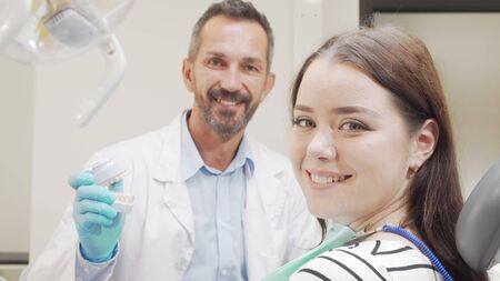 Attractive woman smiling to the camera during appointment with the dentistの写真素材