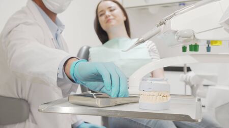Professional dentist examining teeth of a female patient