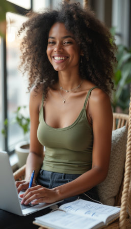 Smiling woman working on a laptop in a cozy settingの素材