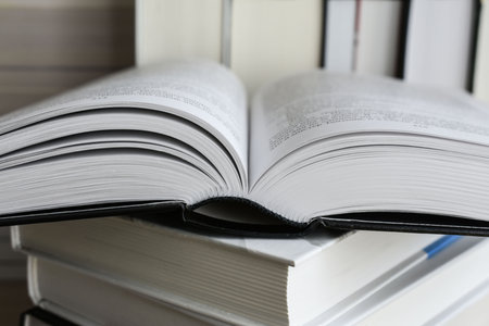 Close-up open book with library bookshelf books backgroundの写真素材
